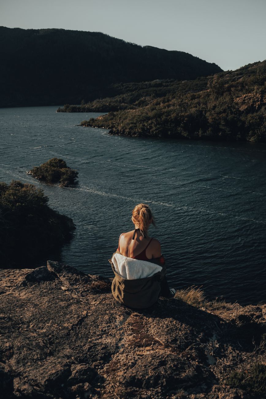 Travel writer taking notes beside Nordic lake cabin
